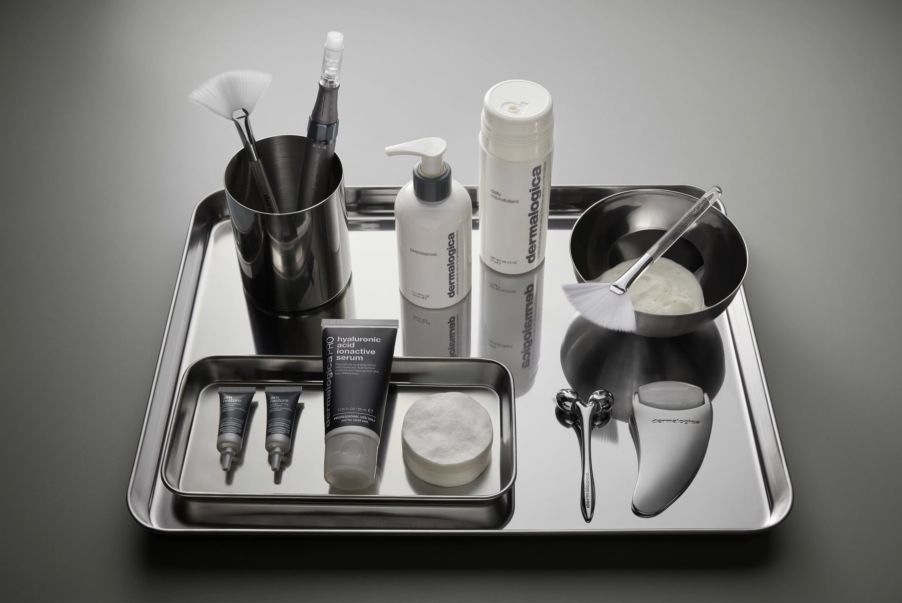 Professionelle Dermalogica-Pflegeprodukte und Behandlungswerkzeuge auf einem Tablett